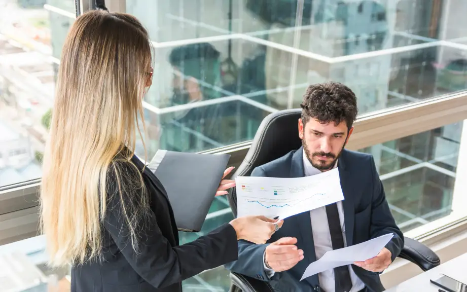 Dos profesionales revisando un gráfico en una oficina moderna